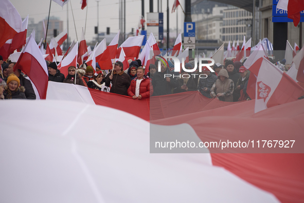 People carry a huge Polish national flag as they participate in the 106th anniversary of Poland's regaining its independence in Warsaw, Pola...