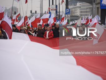 People carry a huge Polish national flag as they participate in the 106th anniversary of Poland's regaining its independence in Warsaw, Pola...