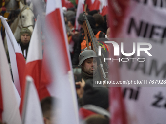 A man dressed as a WWII soldier marches as he participates in the 106th anniversary of Poland regaining its independence in Warsaw, Poland,...