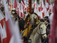 People watch a rehearsal group on horseback and wave Poland's national flags as they participate in the 106th anniversary of Poland regainin...