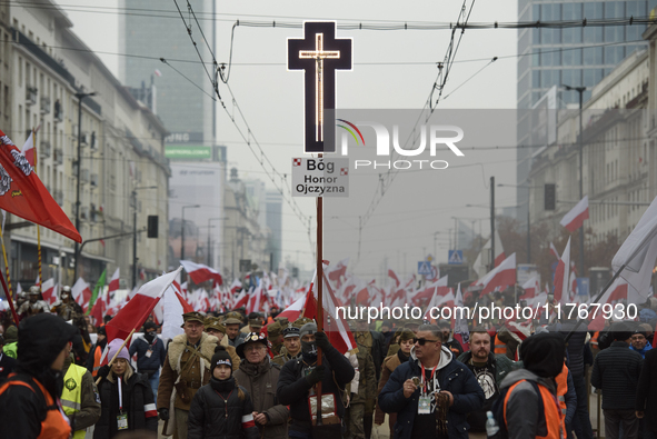 People wave Poland's national flags as they participate in the 106th anniversary of Poland regaining its independence in Warsaw, Poland, on...