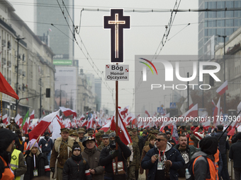 People wave Poland's national flags as they participate in the 106th anniversary of Poland regaining its independence in Warsaw, Poland, on...