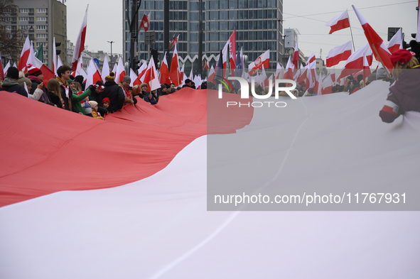 People carry a huge Polish national flag as they participate in the 106th anniversary of Poland's regaining its independence in Warsaw, Pola...