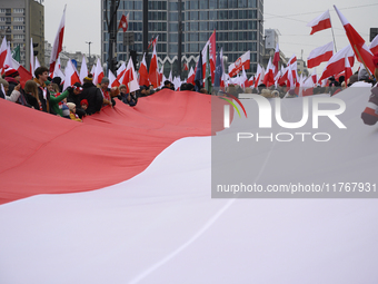 People carry a huge Polish national flag as they participate in the 106th anniversary of Poland's regaining its independence in Warsaw, Pola...