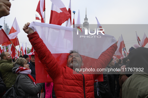 A man holds a national flag of Poland as he participates in the 106th anniversary of Poland's regaining its independence in Warsaw, Poland,...