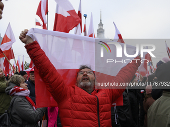 A man holds a national flag of Poland as he participates in the 106th anniversary of Poland's regaining its independence in Warsaw, Poland,...