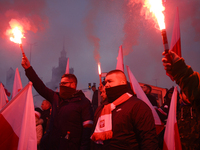 People hold flares as they participate in the 106th anniversary of Poland regaining its independence in Warsaw, Poland, on November 11, 2023...