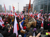 People watch a rehearsal group on horseback and wave Poland's national flags as they participate in the 106th anniversary of Poland regainin...