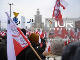 People wave Poland's national flags as they participate in the 106th anniversary of Poland regaining its independence in Warsaw, Poland, on...