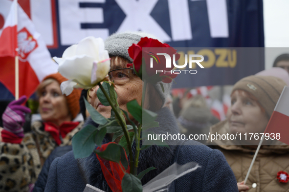 A woman holds roses in the colors of Poland's national flag as she participates in the 106th anniversary of Poland regaining its independenc...