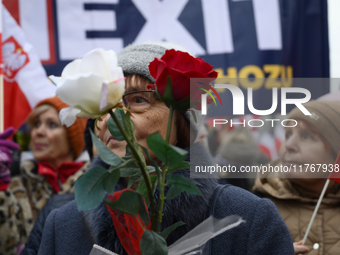 A woman holds roses in the colors of Poland's national flag as she participates in the 106th anniversary of Poland regaining its independenc...