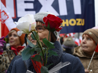 A woman holds roses in the colors of Poland's national flag as she participates in the 106th anniversary of Poland regaining its independenc...