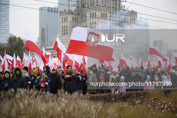 People wave Poland's national flags as they participate in the 106th anniversary of Poland regaining its independence in Warsaw, Poland, on...