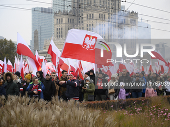 People wave Poland's national flags as they participate in the 106th anniversary of Poland regaining its independence in Warsaw, Poland, on...