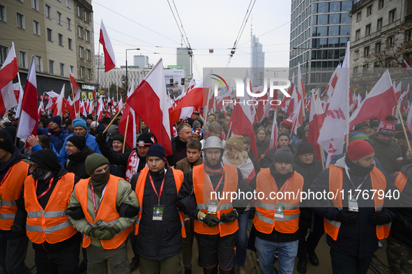 People wave Poland's national flags as they participate in the 106th anniversary of Poland regaining its independence in Warsaw, Poland, on...