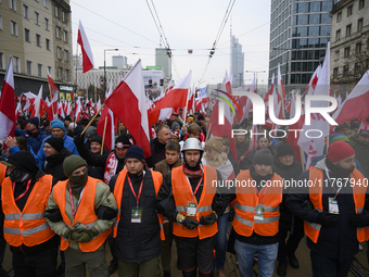 People wave Poland's national flags as they participate in the 106th anniversary of Poland regaining its independence in Warsaw, Poland, on...