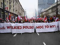 People carry a banner that reads ''We are Greater Poland's Power'' and wave white-red flags as they participate in the 106th anniversary of...