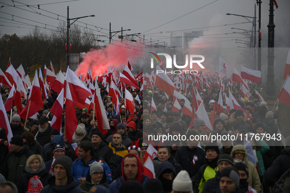 People wave Poland's national flags as they participate in the 106th anniversary of Poland regaining its independence in Warsaw, Poland, on...