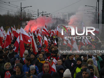 People wave Poland's national flags as they participate in the 106th anniversary of Poland regaining its independence in Warsaw, Poland, on...