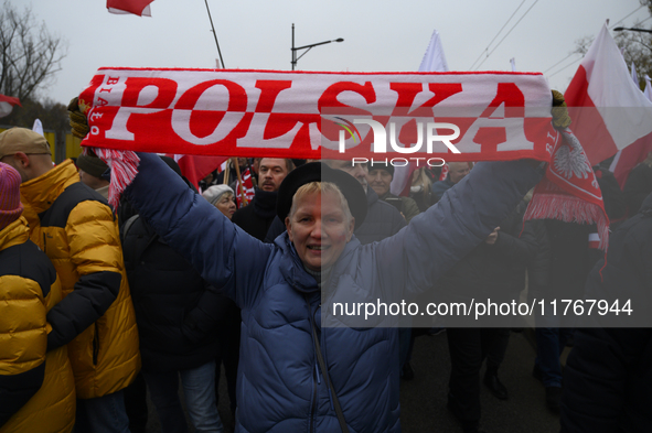 A woman holds a scarf that reads ''Poland'' as she participates in the 106th anniversary of Poland's regaining its independence in Warsaw, P...