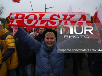 A woman holds a scarf that reads ''Poland'' as she participates in the 106th anniversary of Poland's regaining its independence in Warsaw, P...