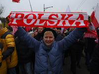 A woman holds a scarf that reads ''Poland'' as she participates in the 106th anniversary of Poland's regaining its independence in Warsaw, P...