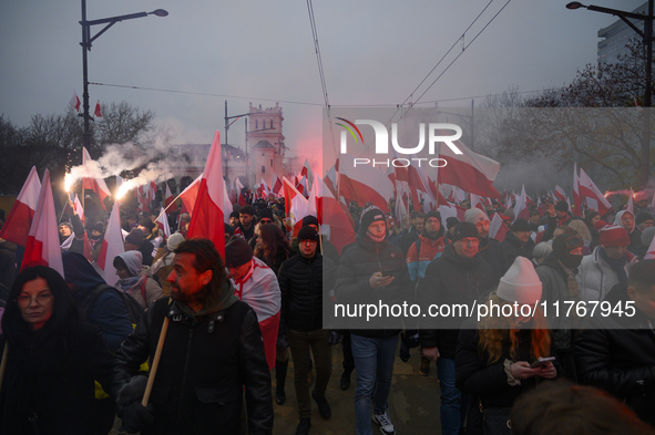 People wave Poland's national flags as they participate in the 106th anniversary of Poland regaining its independence in Warsaw, Poland, on...