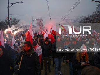 People wave Poland's national flags as they participate in the 106th anniversary of Poland regaining its independence in Warsaw, Poland, on...