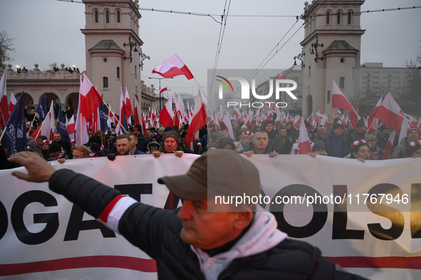 People wave Poland's national flags as they participate in the 106th anniversary of Poland regaining its independence in Warsaw, Poland, on...