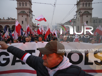 People wave Poland's national flags as they participate in the 106th anniversary of Poland regaining its independence in Warsaw, Poland, on...