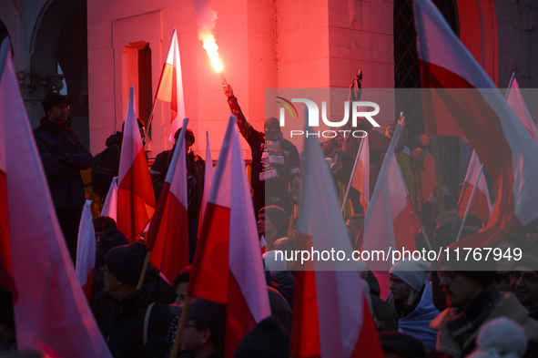 People wave Poland's national flags and light flares as they participate in the 106th anniversary of Poland regaining its independence in Wa...