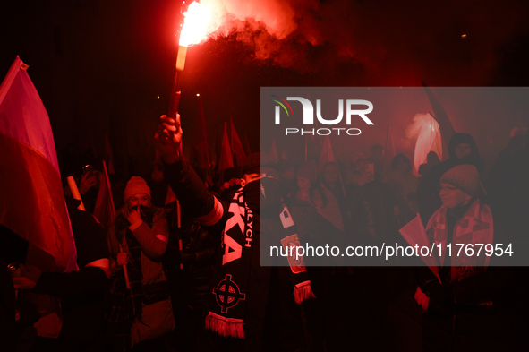 A demonstrator lights a flare as he takes part in the 106th anniversary of Poland regaining its independence in Warsaw, Poland, on November...