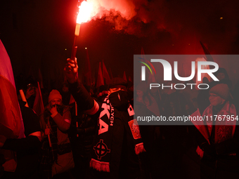 A demonstrator lights a flare as he takes part in the 106th anniversary of Poland regaining its independence in Warsaw, Poland, on November...