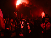 A demonstrator lights a flare as he takes part in the 106th anniversary of Poland regaining its independence in Warsaw, Poland, on November...