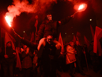 People hold lit flares as they take part in the 106th anniversary of Poland regaining its independence in Warsaw, Poland, on November 11, 20...