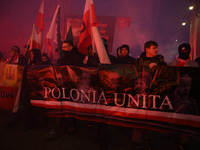 People carry a banner that reads ''Polonia Unita'' as they participate in the 106th anniversary of Poland's regaining its independence in Wa...