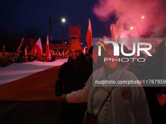 People carry a huge Polish national flag as they participate in the 106th anniversary of Poland's regaining its independence in Warsaw, Pola...