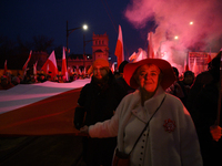 People carry a huge Polish national flag as they participate in the 106th anniversary of Poland's regaining its independence in Warsaw, Pola...