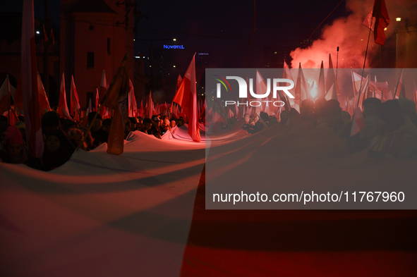 People carry a huge Polish national flag as they participate in the 106th anniversary of Poland's regaining its independence in Warsaw, Pola...