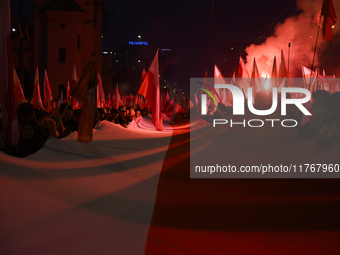 People carry a huge Polish national flag as they participate in the 106th anniversary of Poland's regaining its independence in Warsaw, Pola...