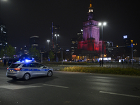 Police block the main road before the Palace of Culture and Science, which is lit in the colors of Poland's national flag during the 106th a...