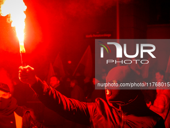 An Independence Day march participant wearing a balaclava lights a flare in Warsaw, Poland on 11 November, 2024. A march organized by far-ri...