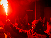 An Independence Day march participant wearing a balaclava lights a flare in Warsaw, Poland on 11 November, 2024. A march organized by far-ri...