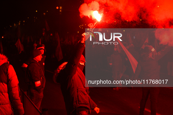 Participants light flares in Warsaw, Poland on 11 November, 2024. A march organized by far-right, nationalist organizations was allowed to p...