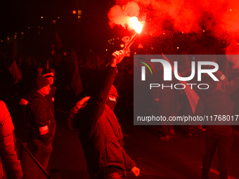 Participants light flares in Warsaw, Poland on 11 November, 2024. A march organized by far-right, nationalist organizations was allowed to p...