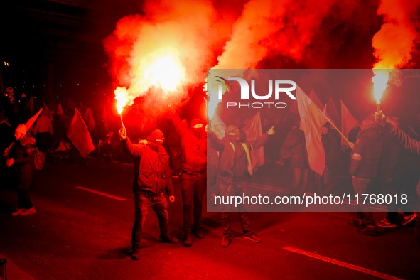 Participants light flares in Warsaw, Poland on 11 November, 2024. A march organized by far-right, nationalist organizations was allowed to p...