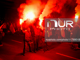 Participants light flares in Warsaw, Poland on 11 November, 2024. A march organized by far-right, nationalist organizations was allowed to p...