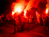 Participants light flares in Warsaw, Poland on 11 November, 2024. A march organized by far-right, nationalist organizations was allowed to p...