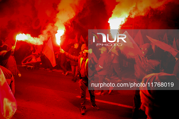 Participants light flares while threatening a journalist in Warsaw, Poland on 11 November, 2024. A march organized by far-right, nationalist...