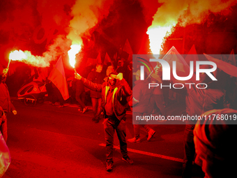 Participants light flares while threatening a journalist in Warsaw, Poland on 11 November, 2024. A march organized by far-right, nationalist...